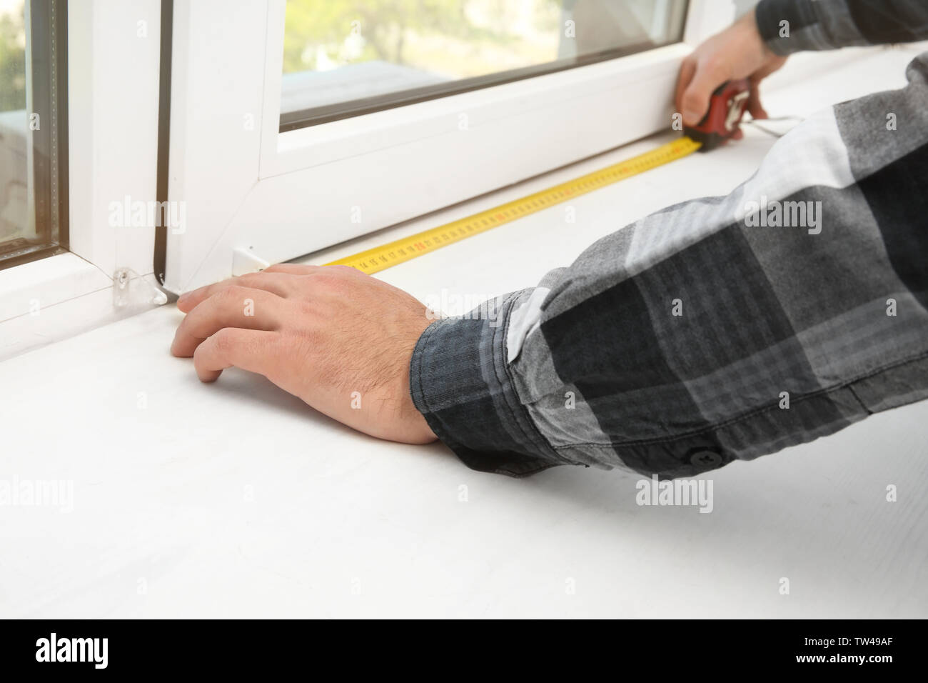 Young man installing window shades at home Stock Photo