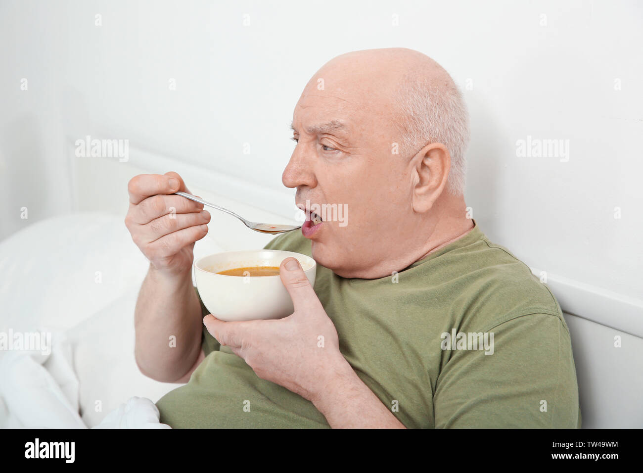 Elderly man eating soup in bed Stock Photo Alamy