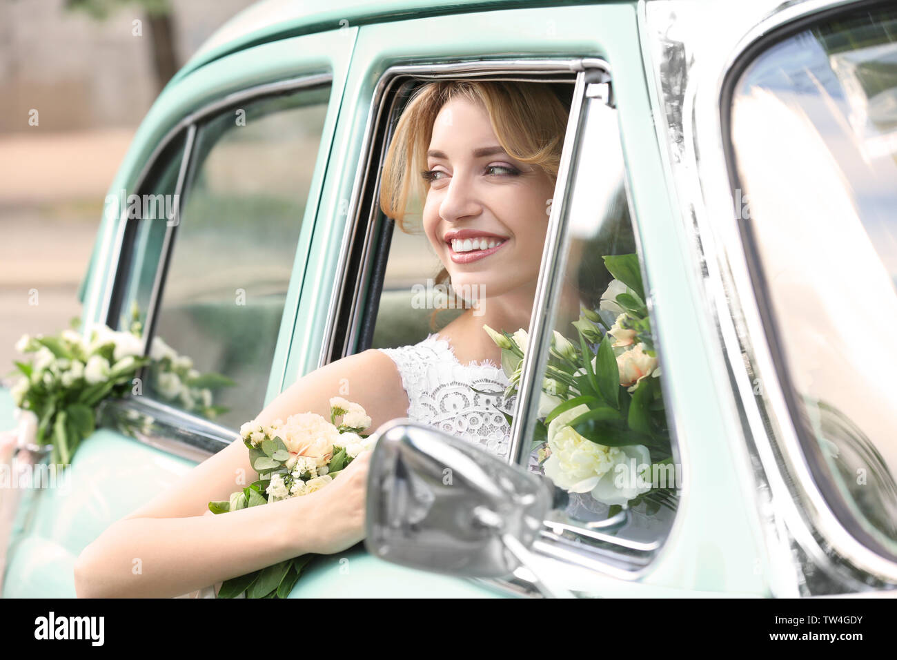 Beautiful young bride in decorated car Stock Photo - Alamy