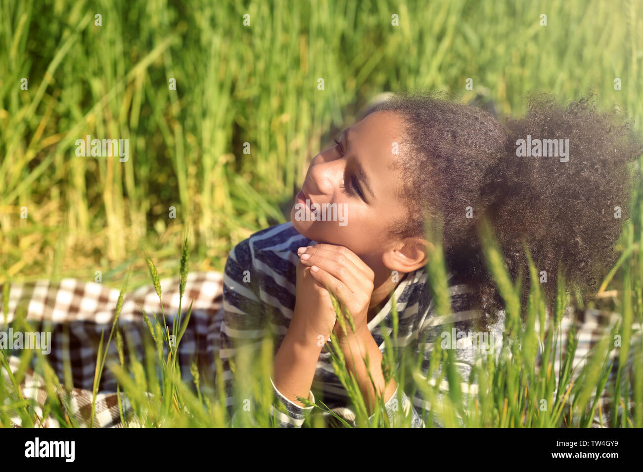 Little Afro American girl in green field Stock Photo - Alamy