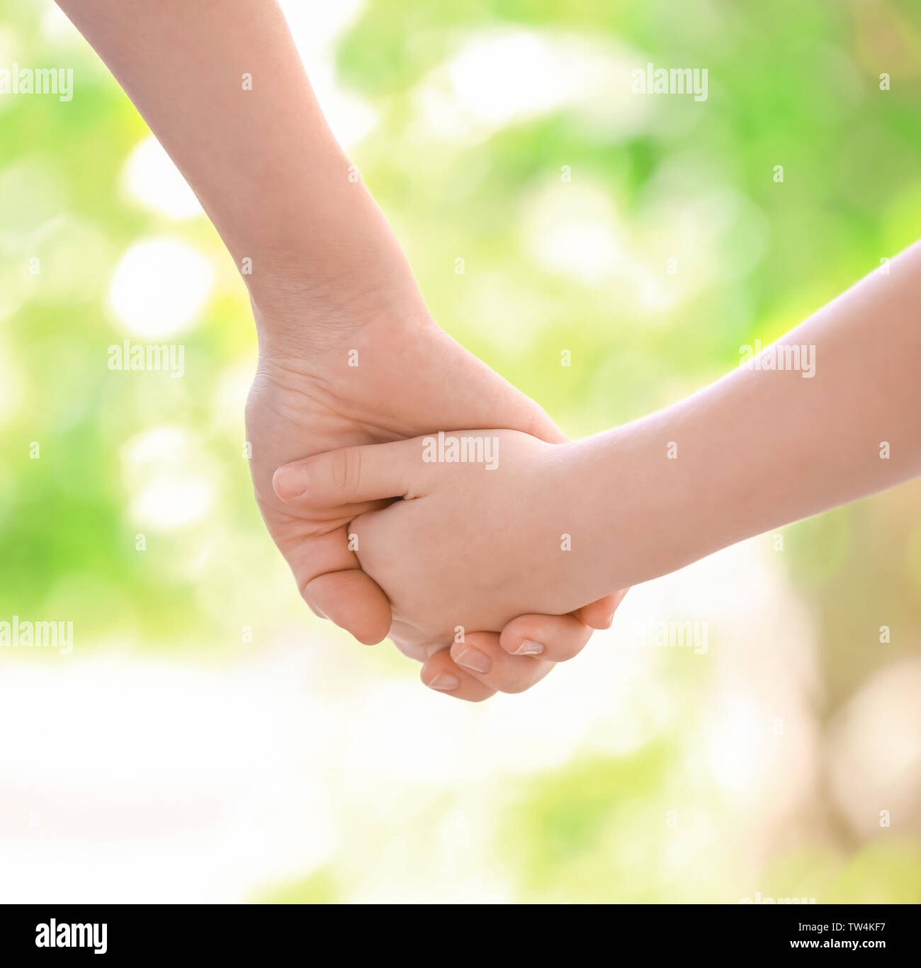 Mother and daughter holding hands together on blurred background Stock ...