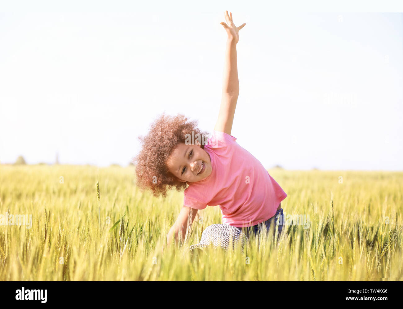 Little Afro American girl in green field Stock Photo - Alamy
