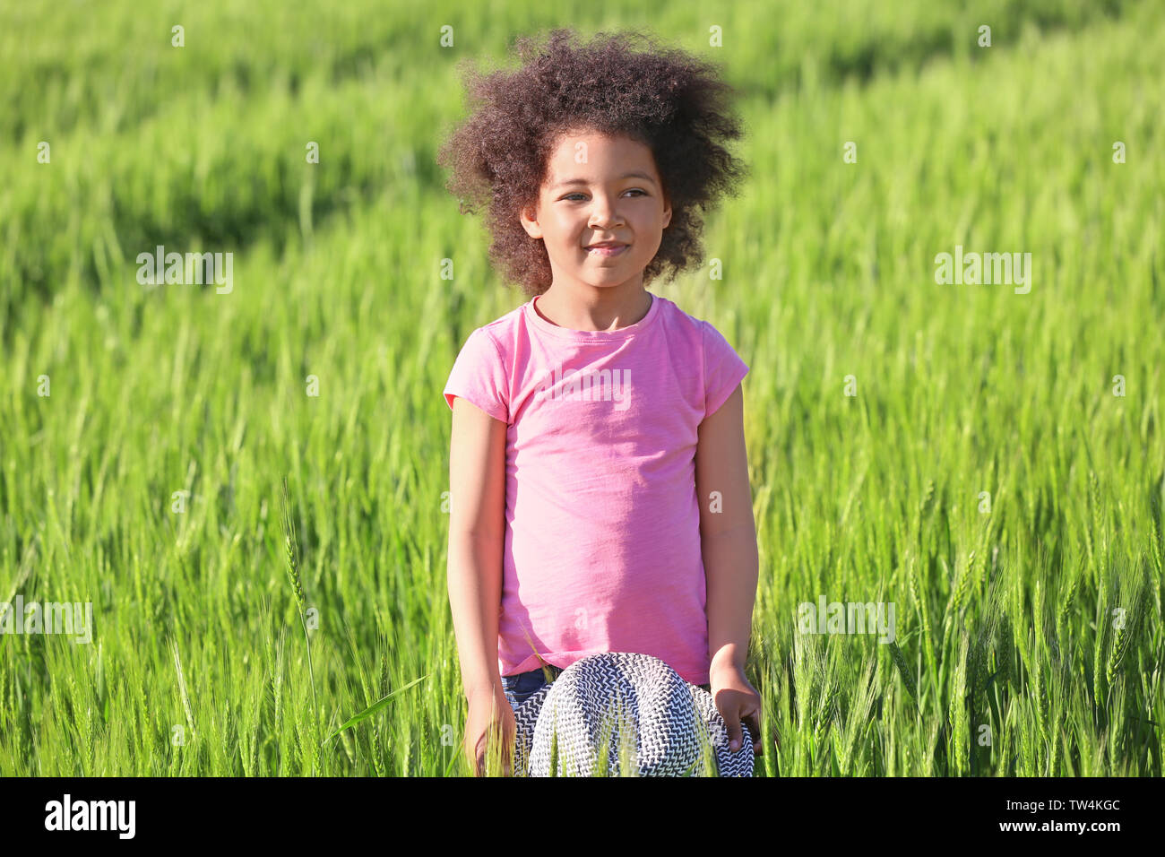Little Afro American girl in green field Stock Photo - Alamy