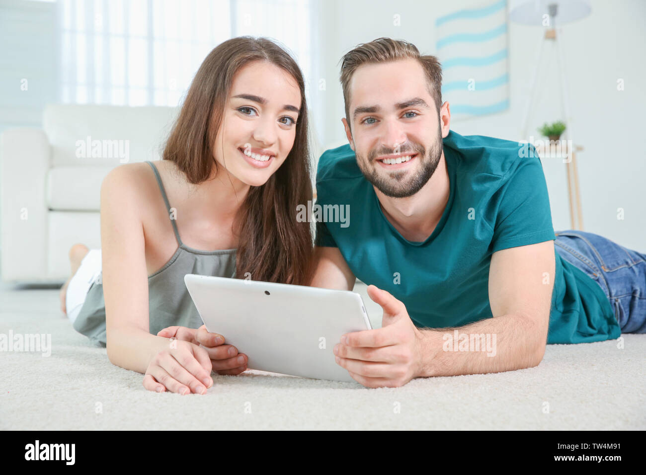 Young couple searching information using tablet at home Stock Photo