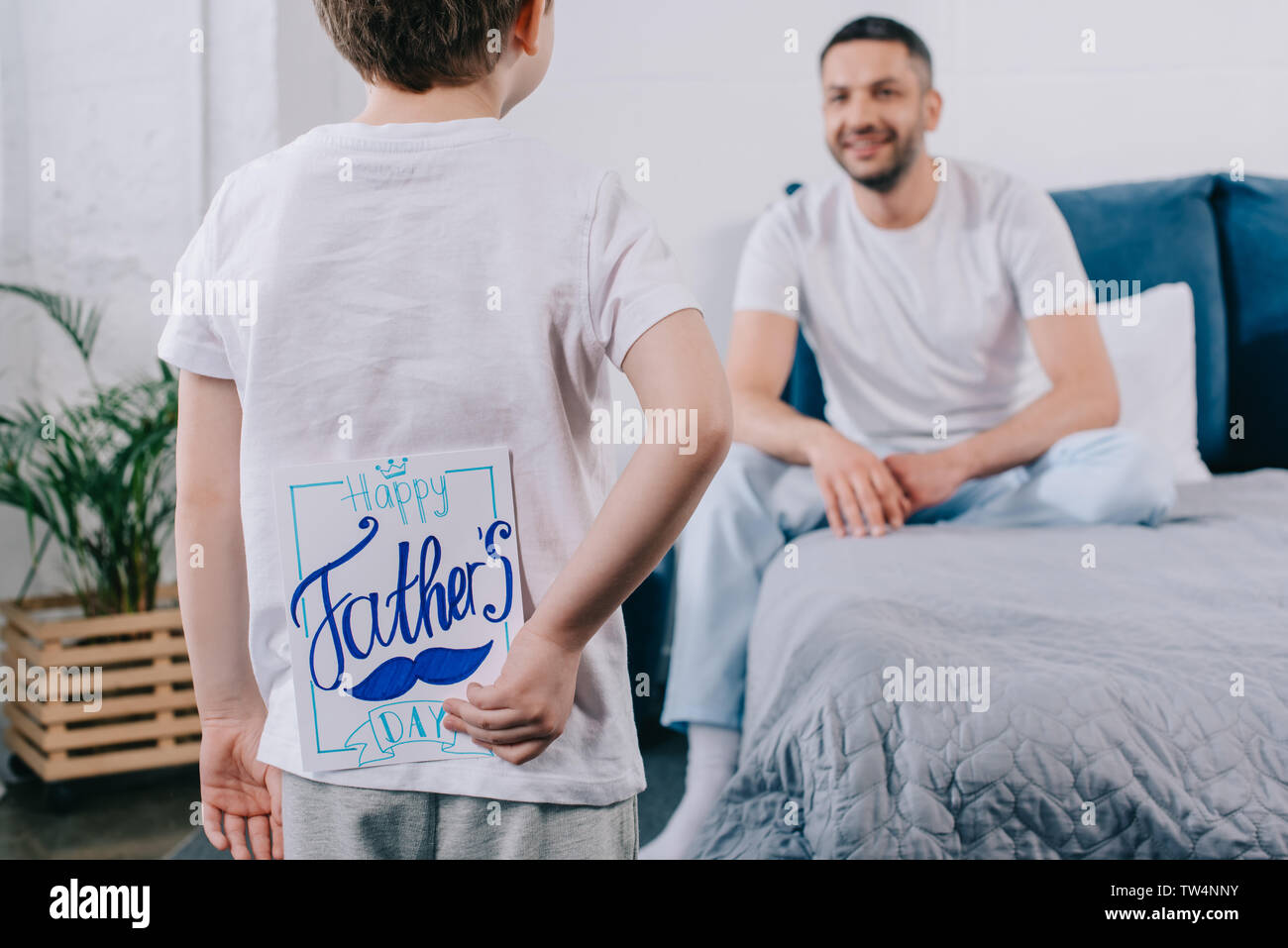 selective focus of child holding fathers day greeting card behind back ...