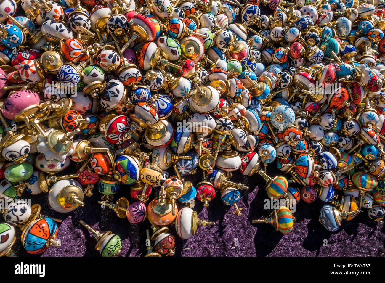 Chamonix, France - 23 March 2019: Hundreds of artisan colourful porcelain and brass doorknobs spread out on display for sale on a market stall table a Stock Photo