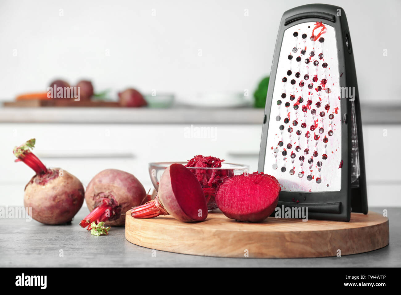 Fresh beetroot and grater on table in kitchen Stock Photo