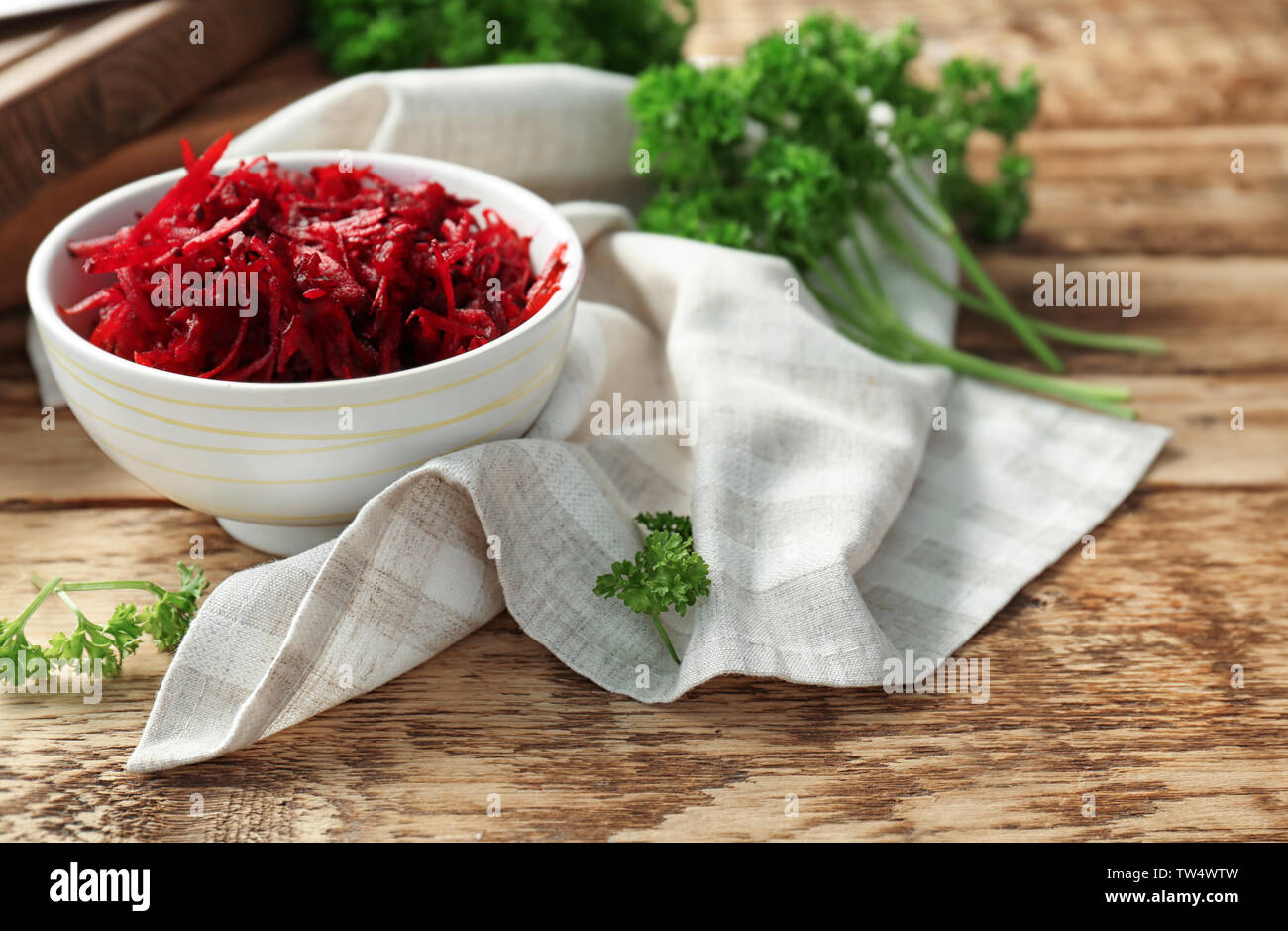 Bowl with grated beetroot on wooden table Stock Photo
