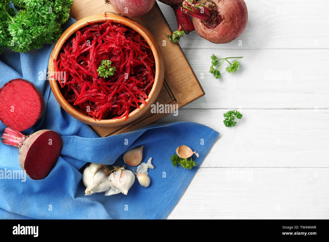 Wooden bowl with grated beetroot on table Stock Photo