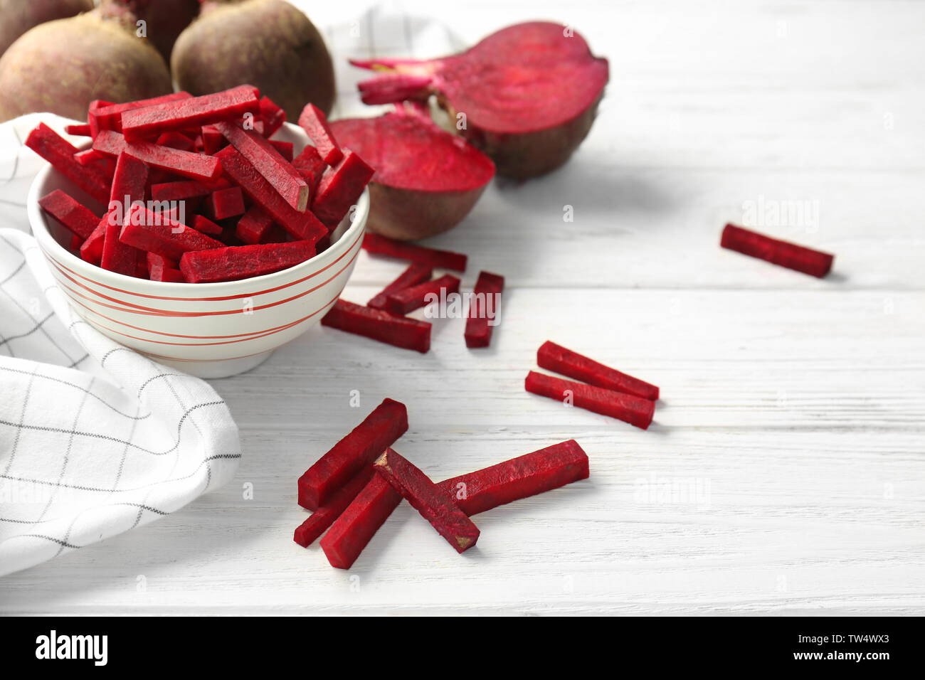 Bowl with sliced beetroot on white wooden table Stock Photo