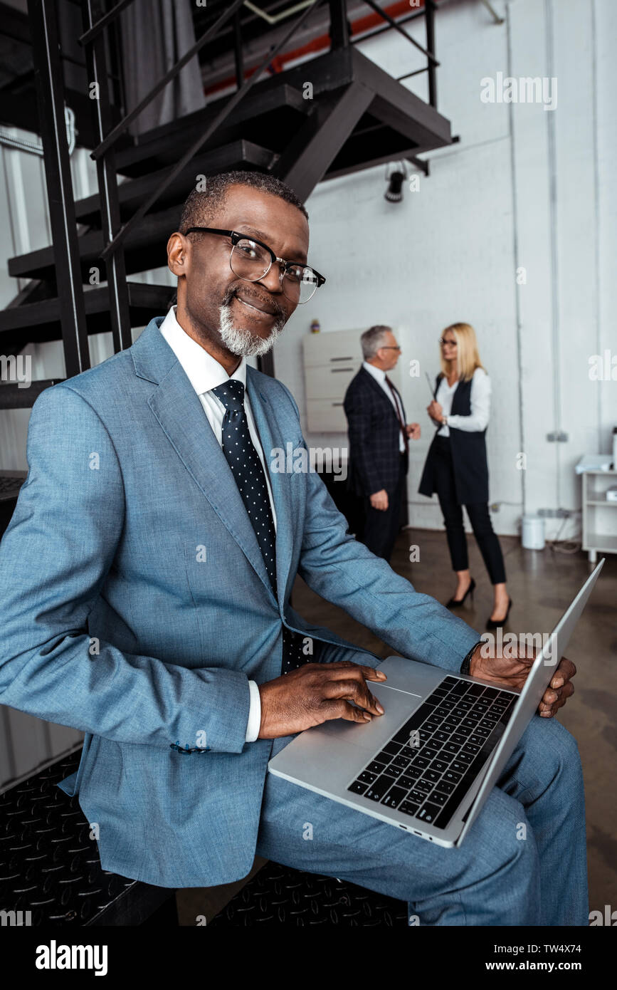 selective focus of happy african american man using laptop near