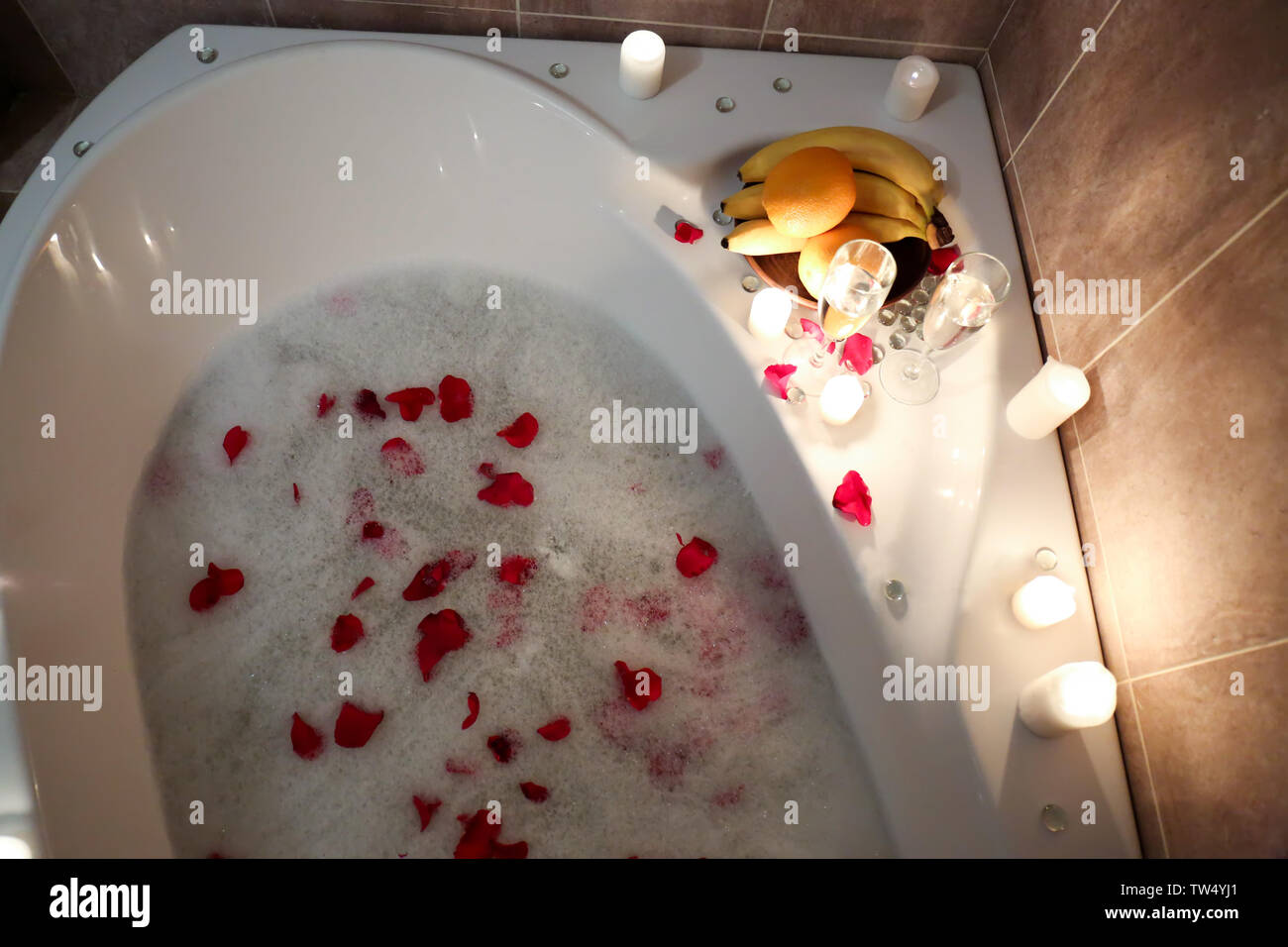 Bathtub filled with foam and rose petals prepared for romantic date Stock  Photo - Alamy