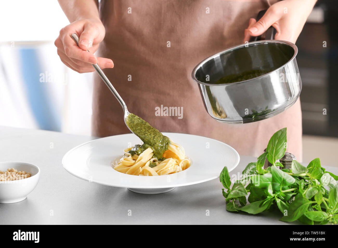 Woman adding basil pasta hi-res stock photography and images - Alamy
