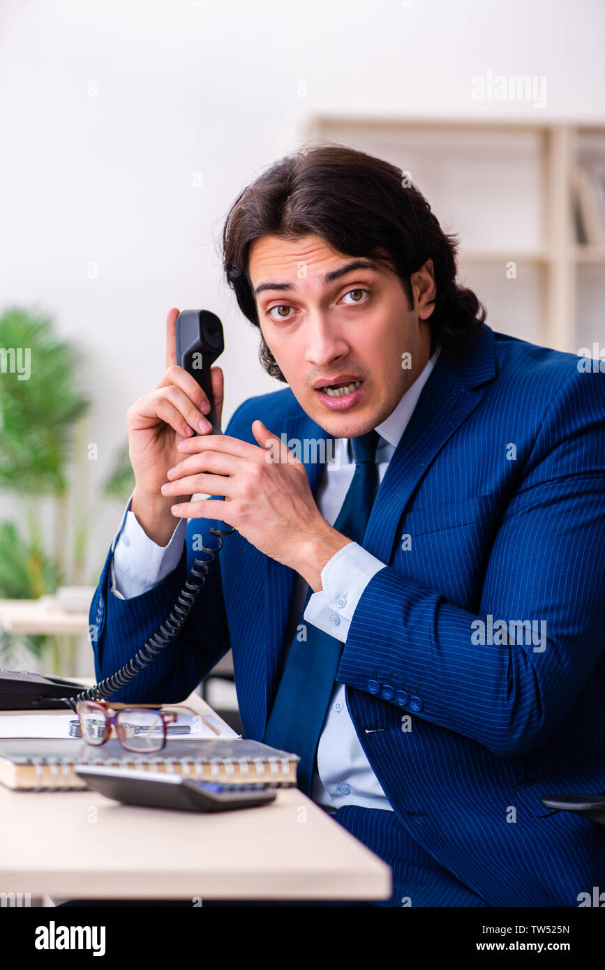 Young businessman sitting and working in the office Stock Photo - Alamy