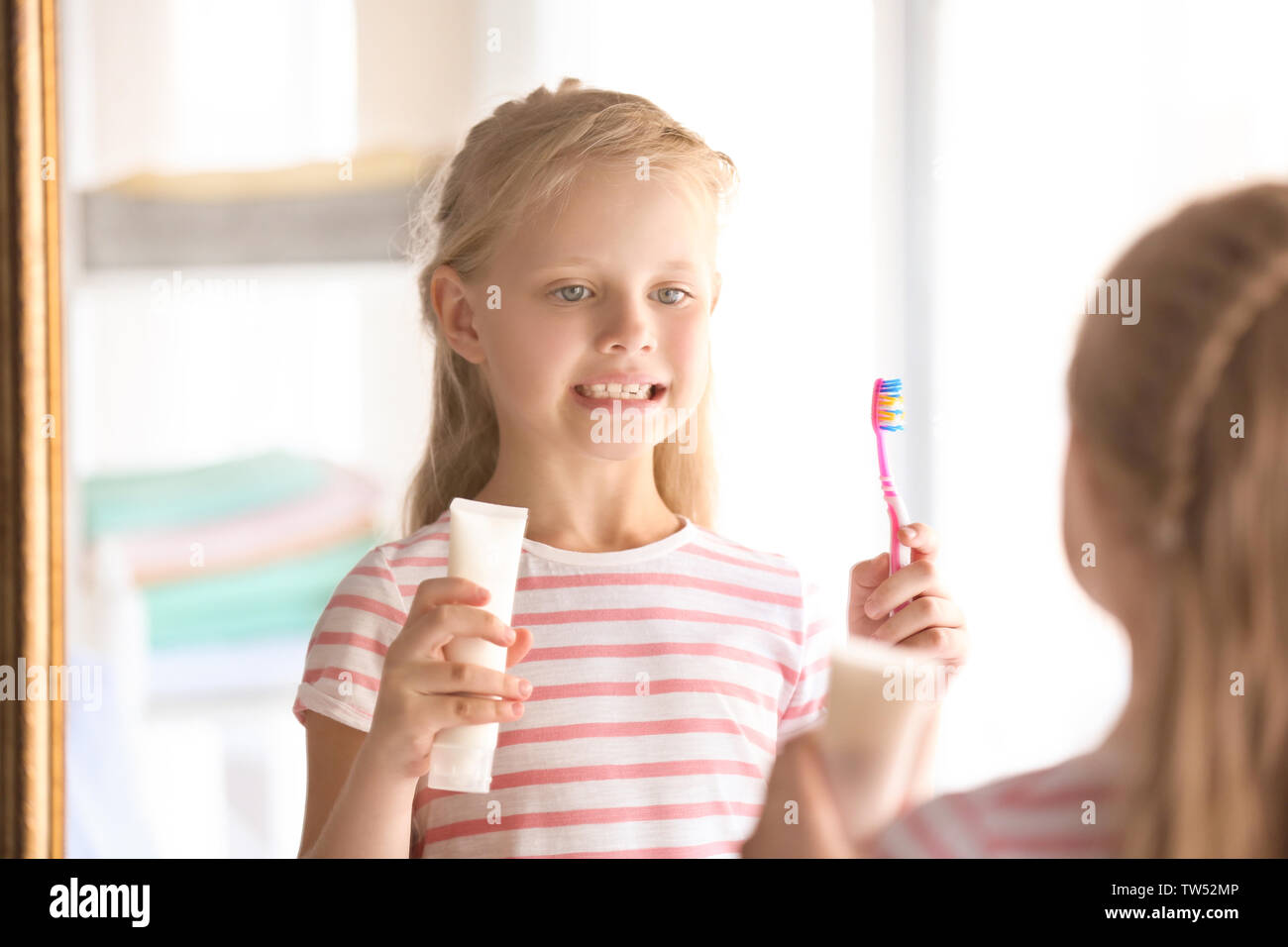 Cute little girl with toothbrush and paste at home. Cleaning teeth
