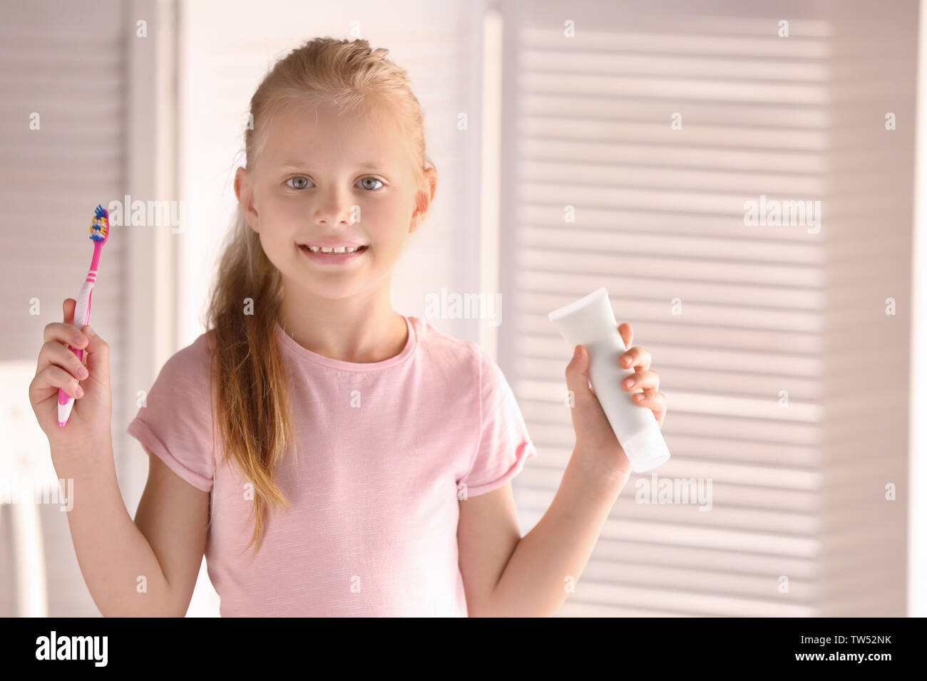 Cute little girl with toothbrush and paste at home. Cleaning teeth