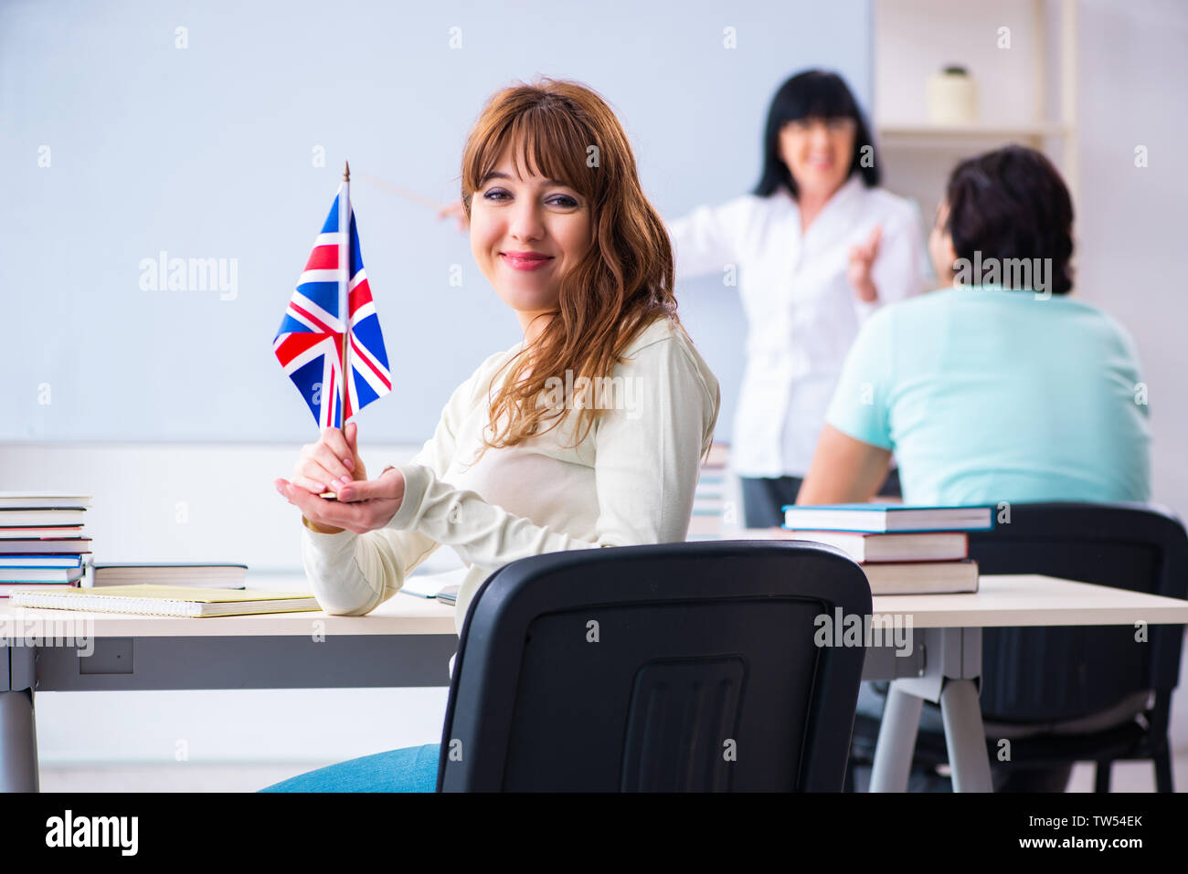 Old female english teacher and students in the classroom Stock Photo