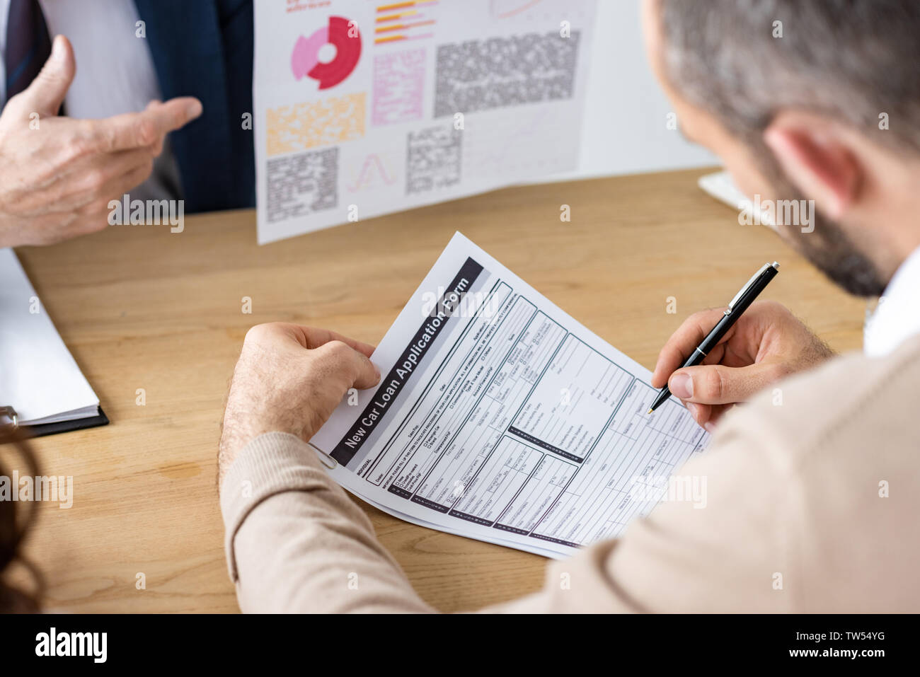 cropped view of man holding pen neat contract and car dealer in office
