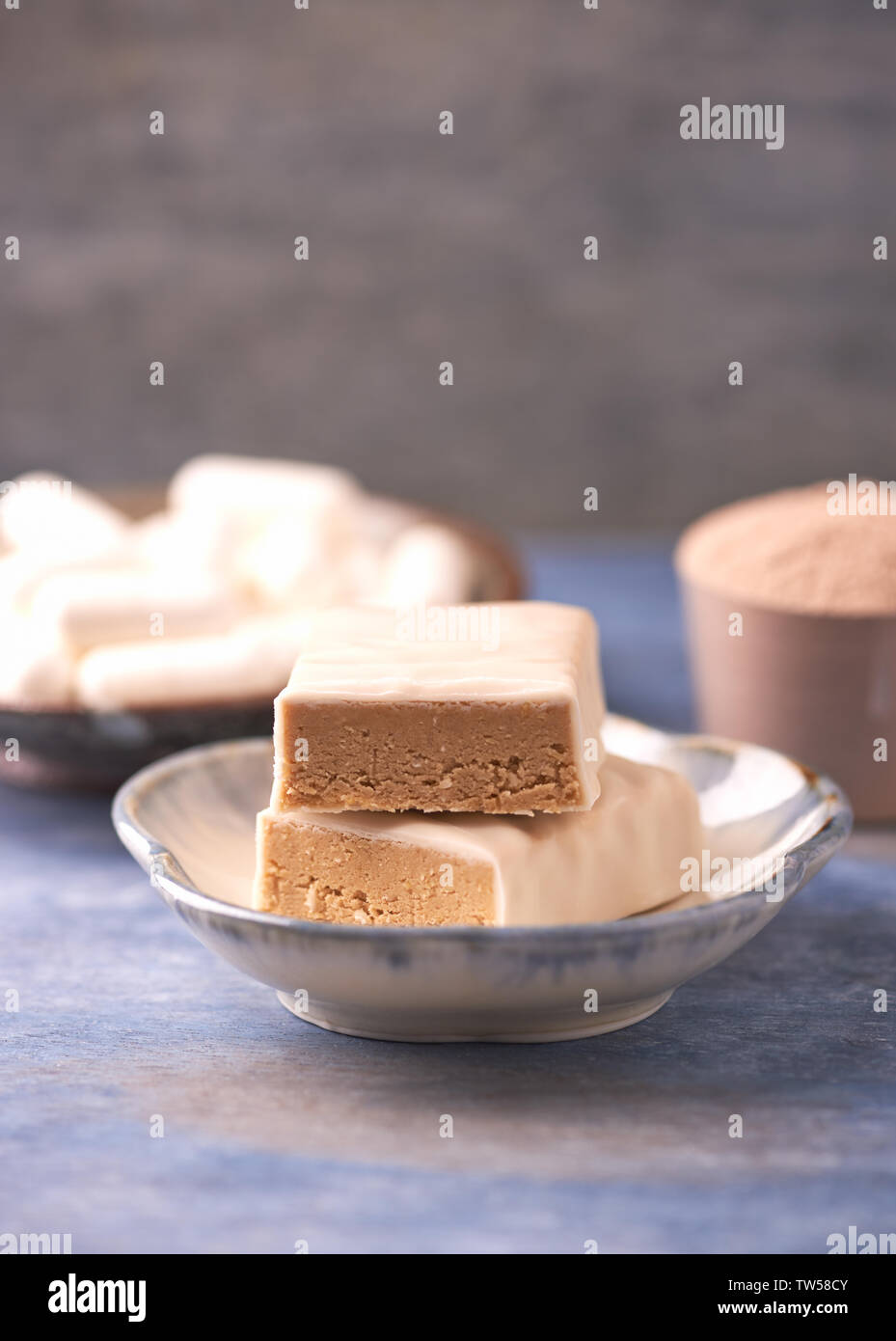 Protein bar in two pieces, creatine capsules and scoop. Bodybuilding food  supplements on rustic wooden background. Copy space Stock Photo - Alamy