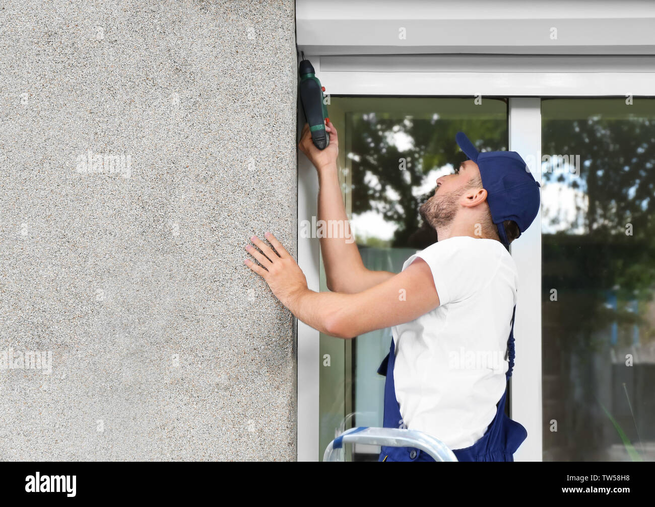 Man installing roller shutter on window Stock Photo