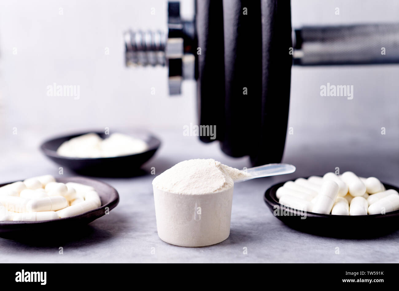 Scoop of Whey Protein, Creatine, Taurine, Beta Alanine capsules and a