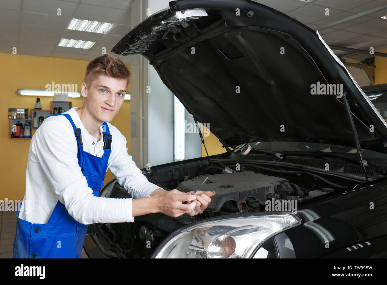 Young mechanic repairing car in body shop Stock Photo