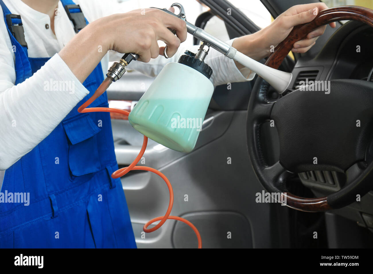 Young man cleaning car salon in body shop Stock Photo