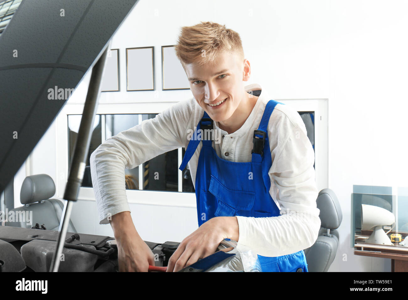 Young mechanic repairing car in body shop Stock Photo