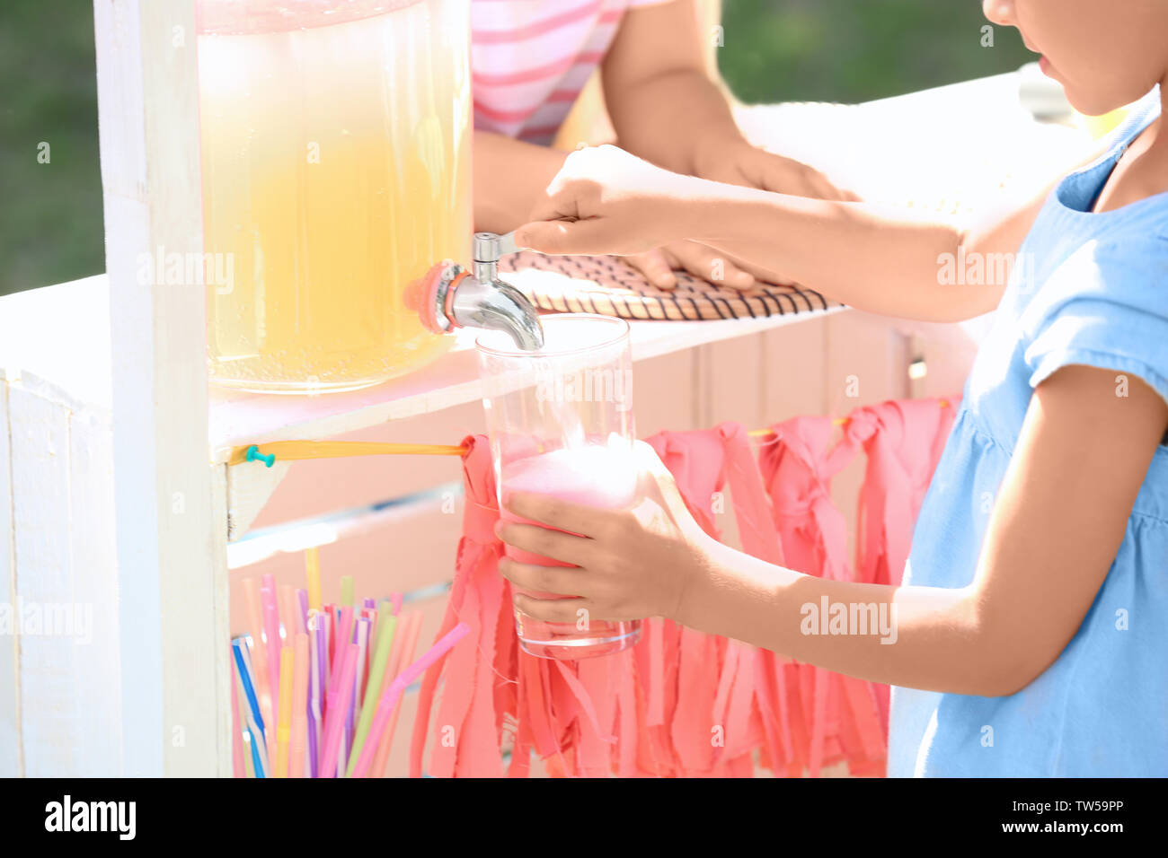 Little girl pouring lemonade from jar with tap Stock Photo Alamy