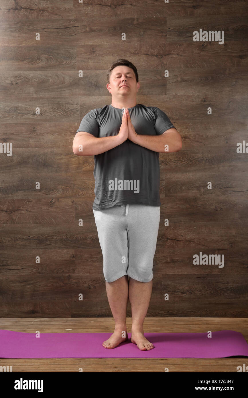 Overweight young man training against wooden wall Stock Photo