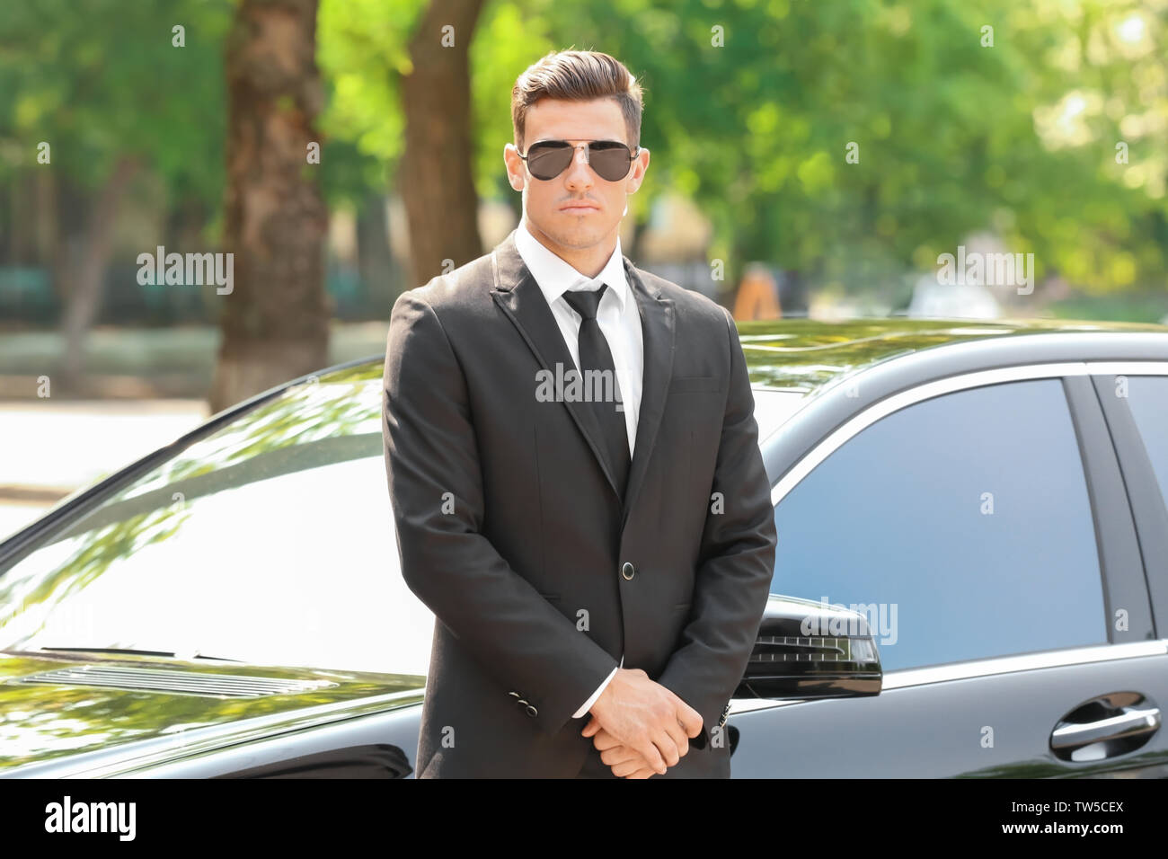 Handsome bodyguard near car outdoors Stock Photo Alamy