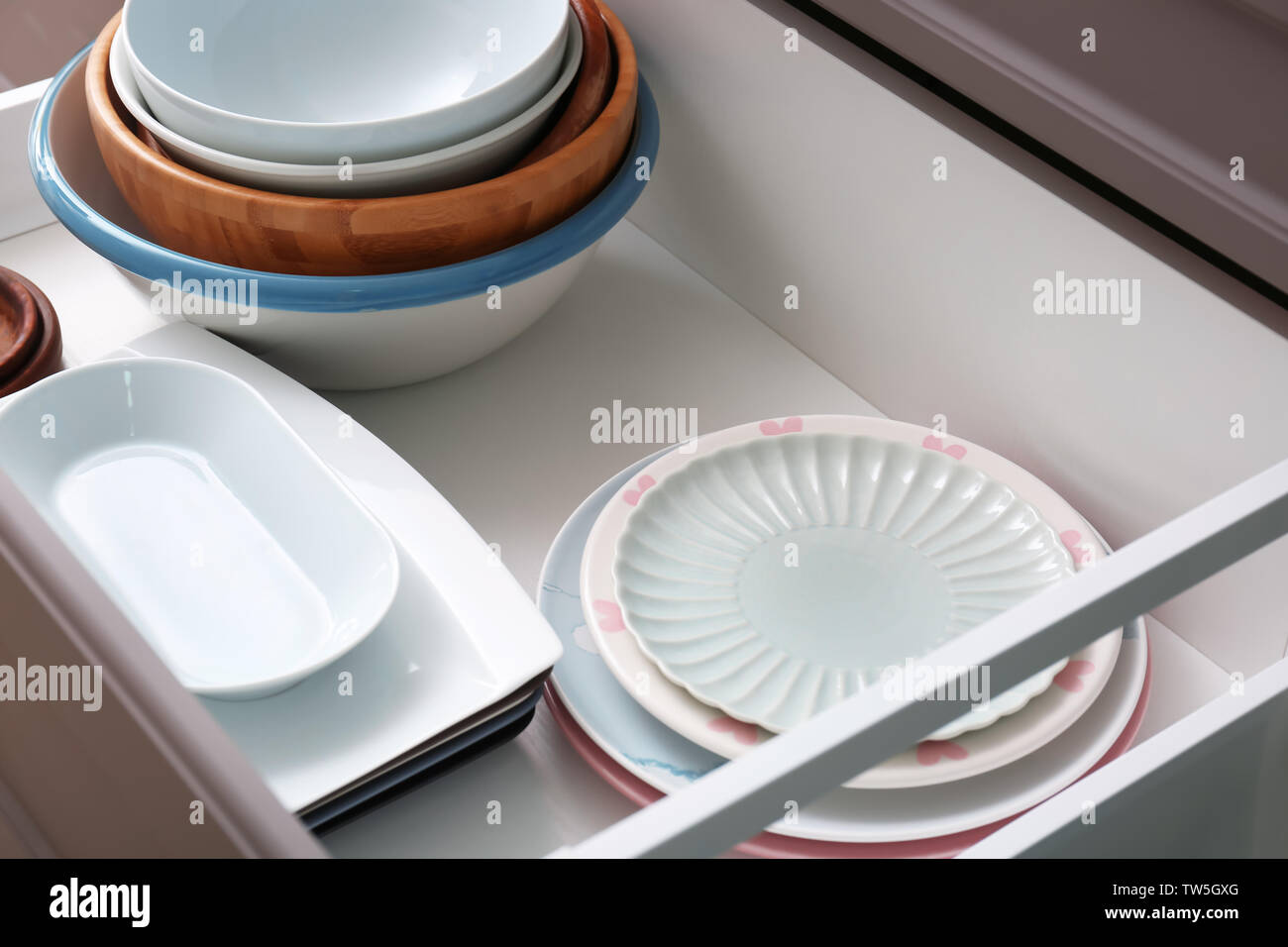 Set of tableware in kitchen drawer Stock Photo - Alamy