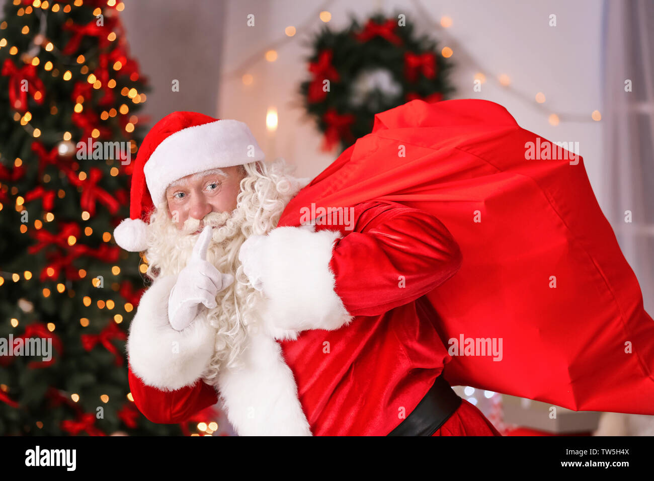 Authentic Santa Claus with big red bag full of gifts against blurred ...