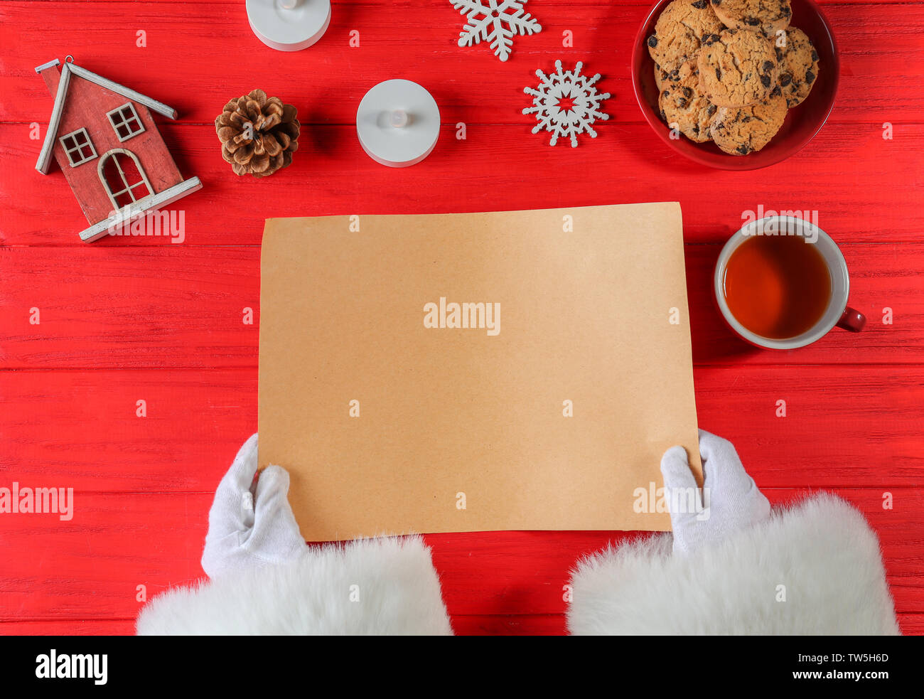 Santa Claus holding blank sheet of paper on red background Stock Photo ...