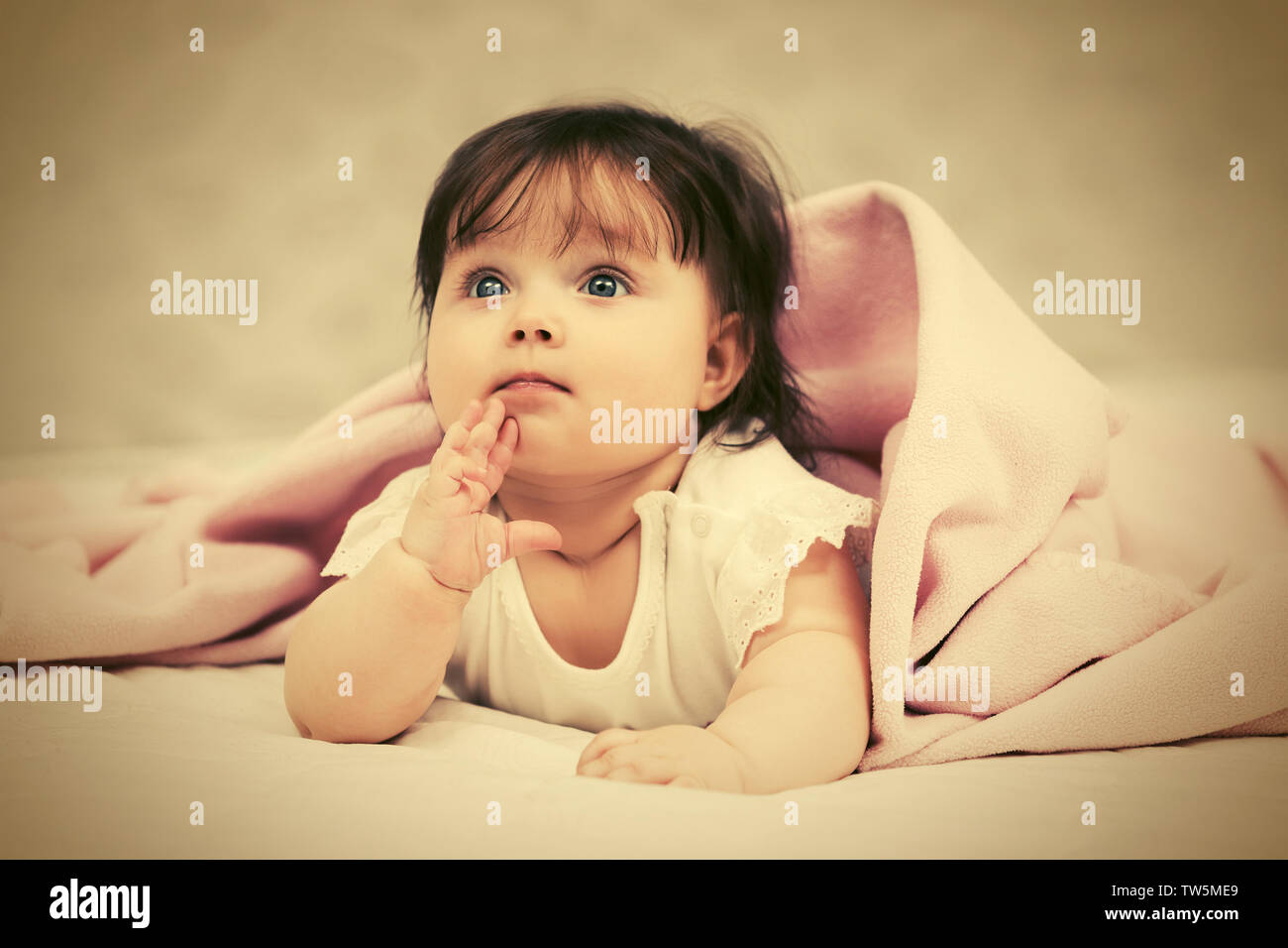 Happy six months old baby girl lying on blanket at home Stock Photo Alamy