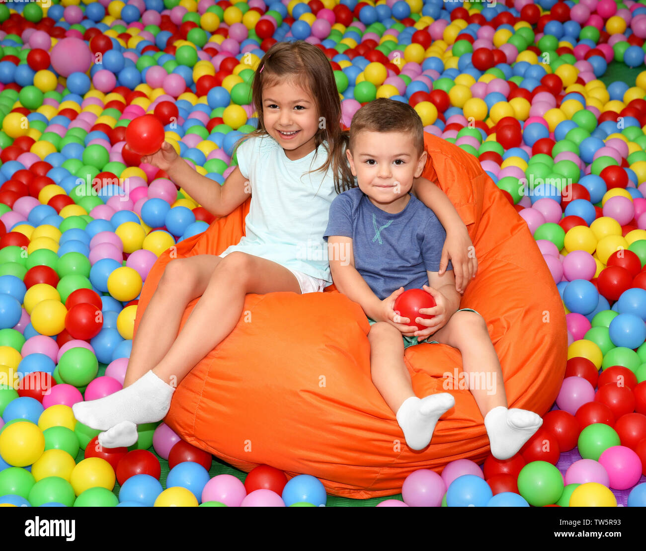 Cute children on beanbag in entertainment center Stock Photo - Alamy