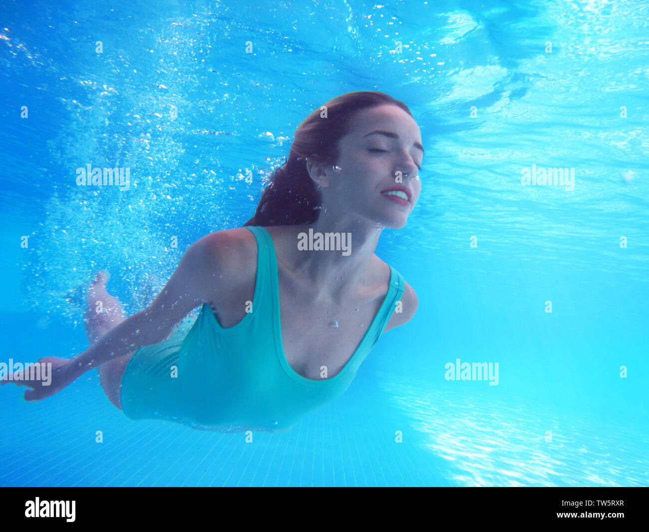 Beautiful young woman swimming under water in pool Stock Photo - Alamy