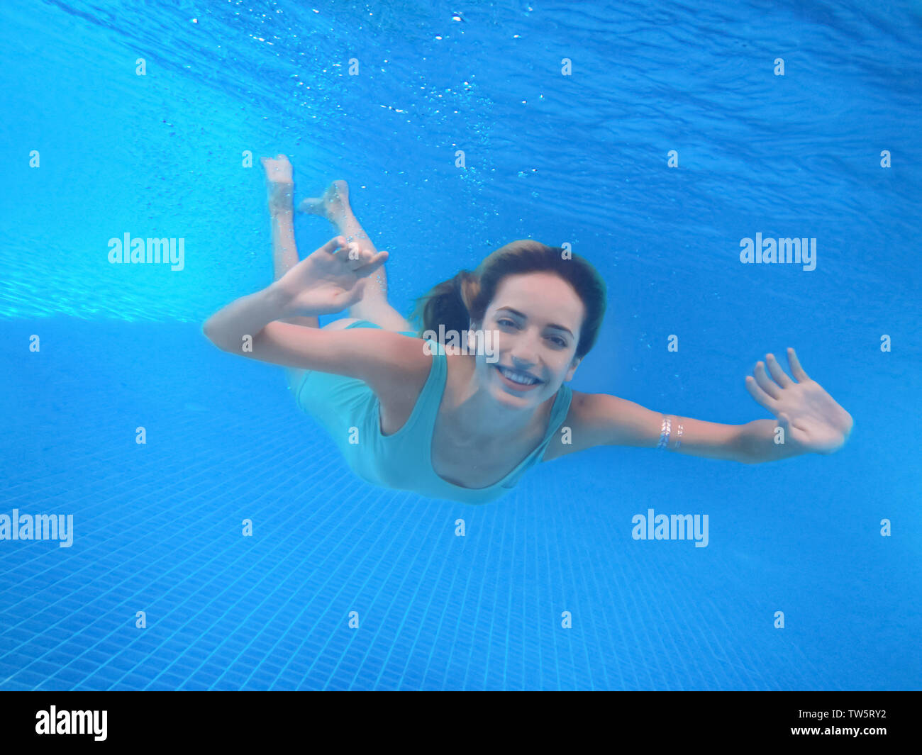 Beautiful young woman swimming under water in pool Stock Photo - Alamy