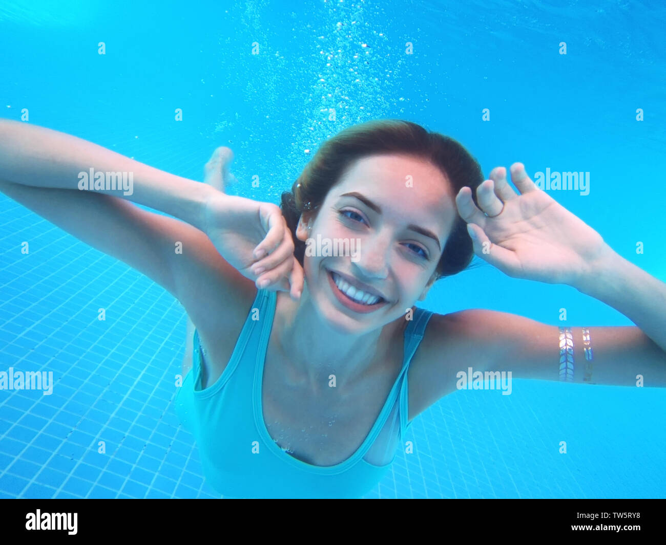 Beautiful young woman swimming under water in pool Stock Photo - Alamy