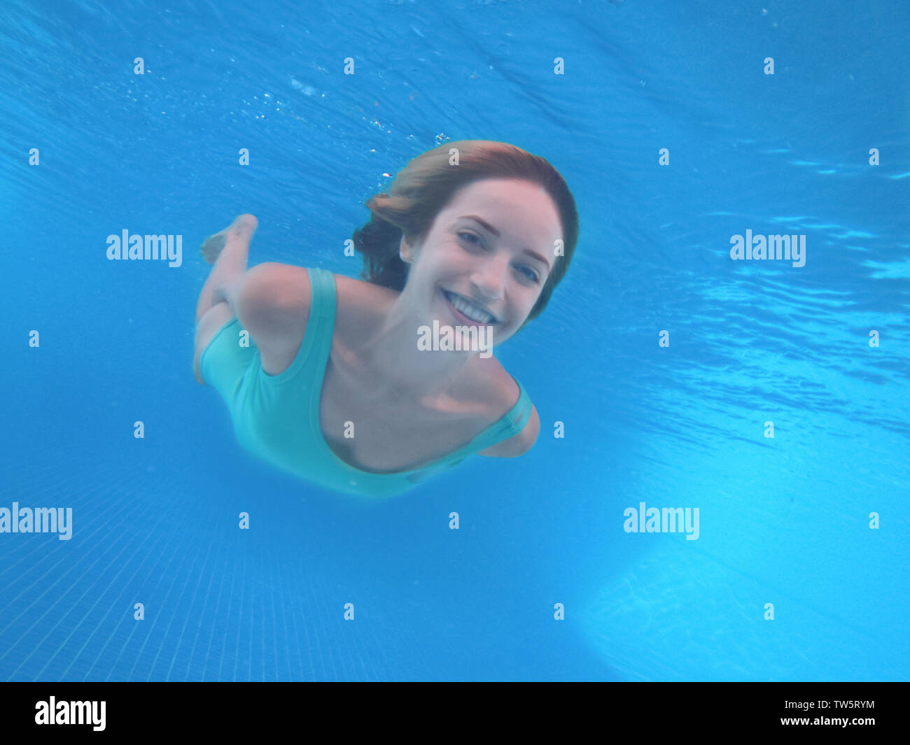 Beautiful young woman swimming under water in pool Stock Photo - Alamy