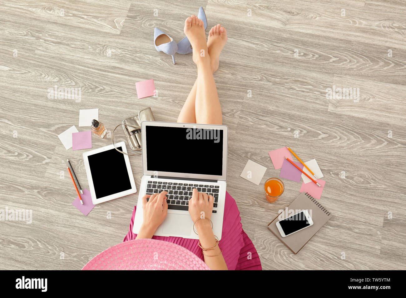 Young beauty blogger using laptop while sitting on floor Stock Photo