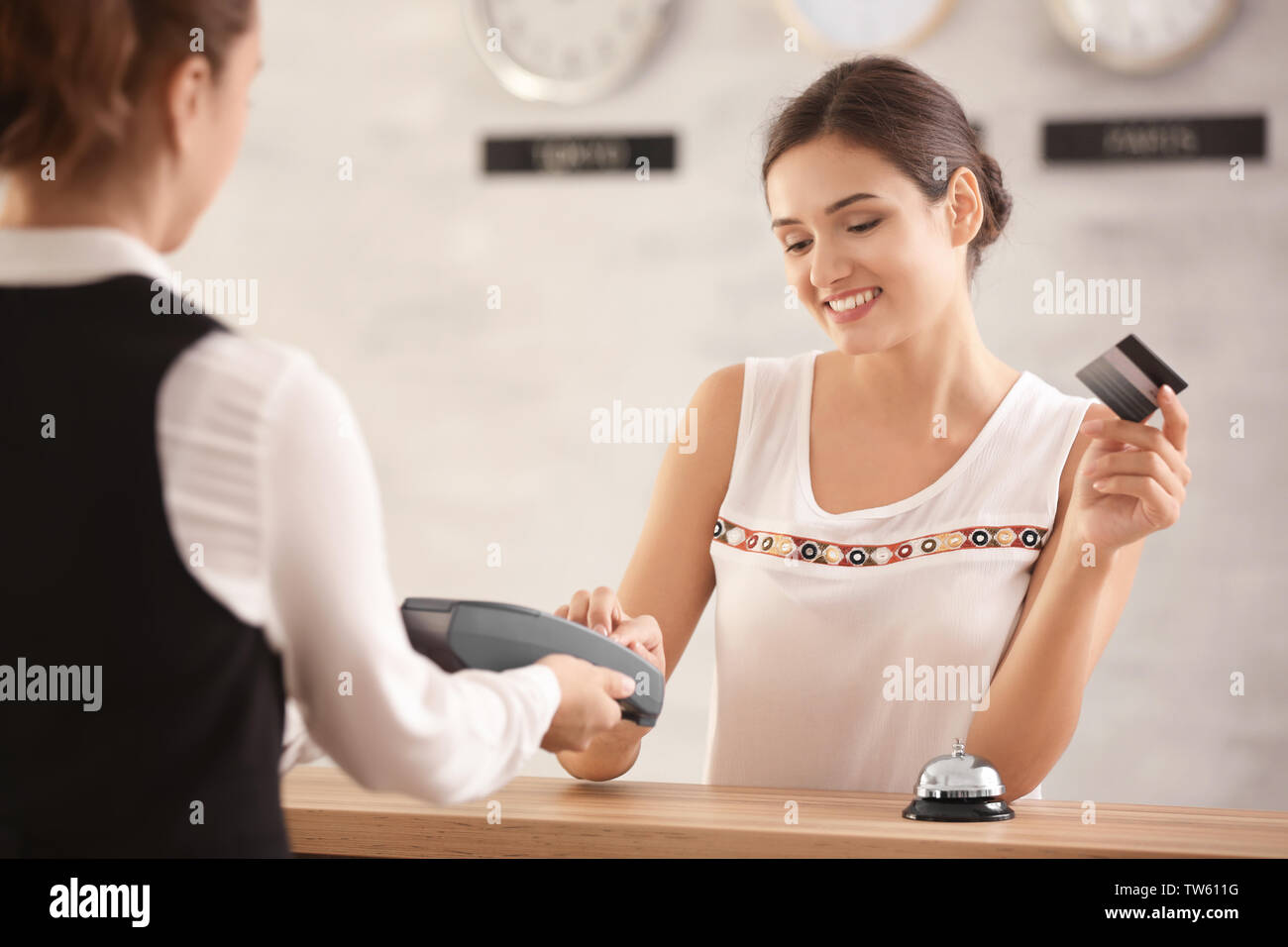 Young woman paying for hotel room at reception Stock Photo Alamy