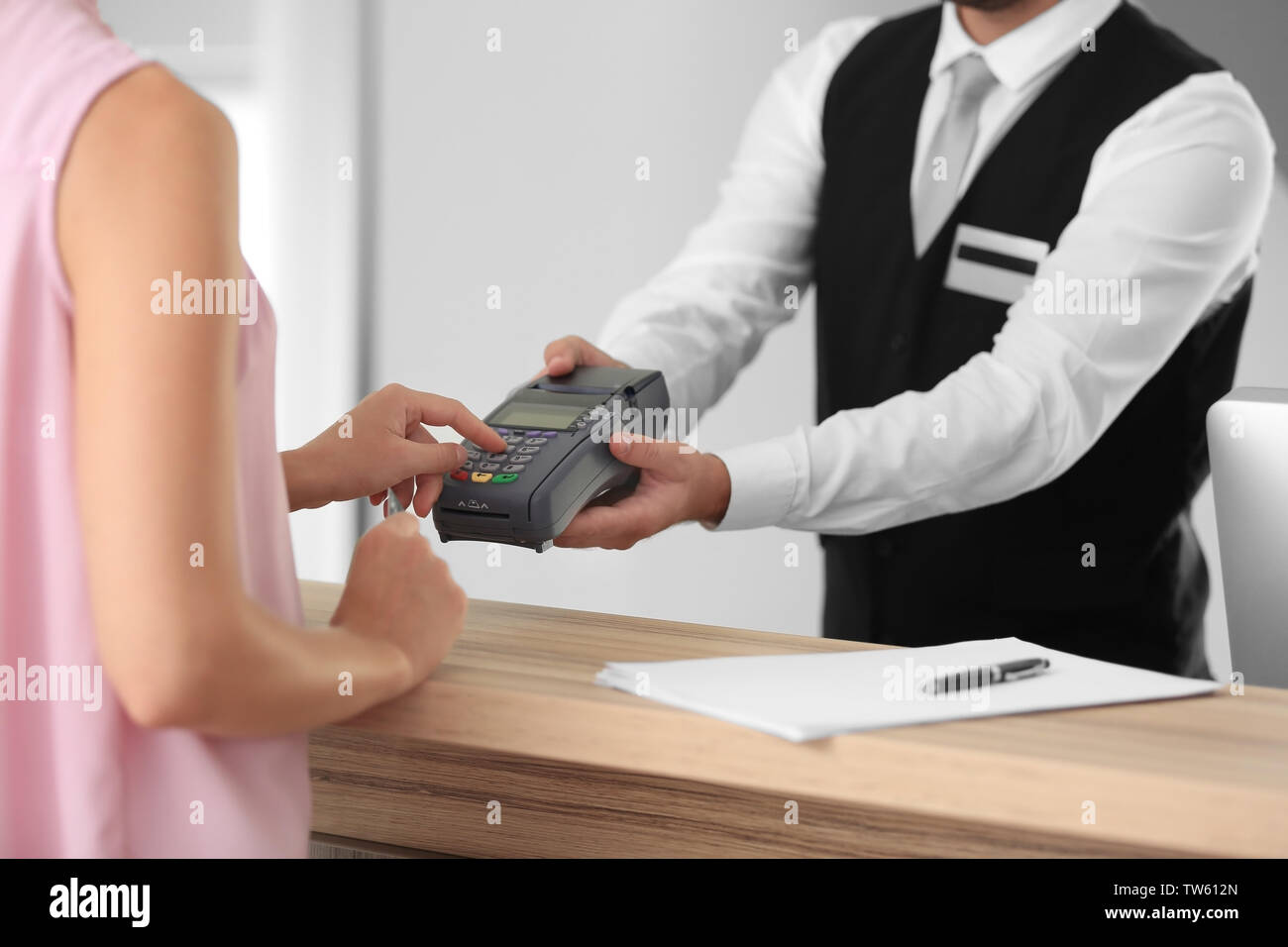Woman paying for hotel room at reception Stock Photo Alamy