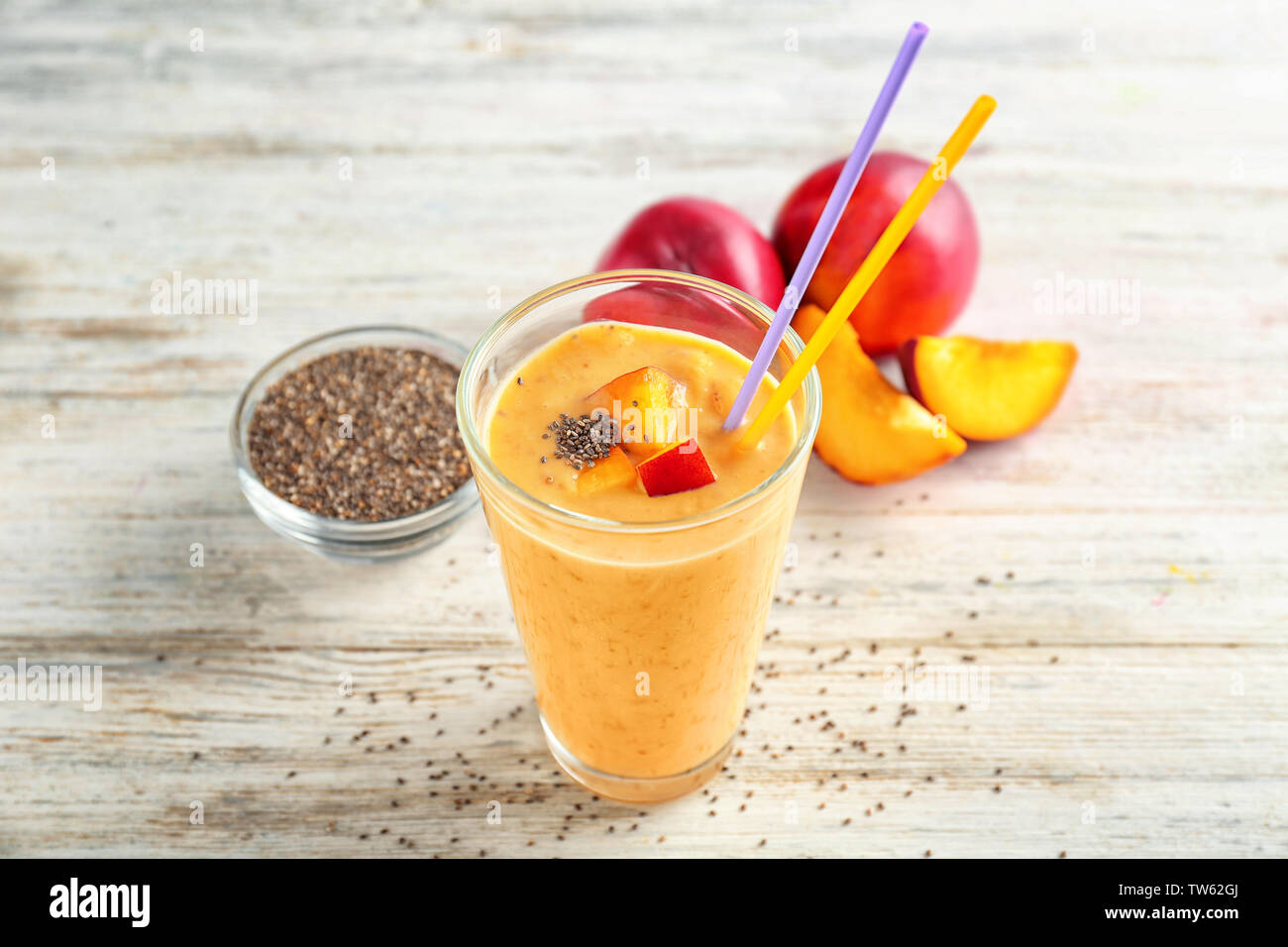 Glass of delicious smoothie with chia seeds and peaches on wooden table ...