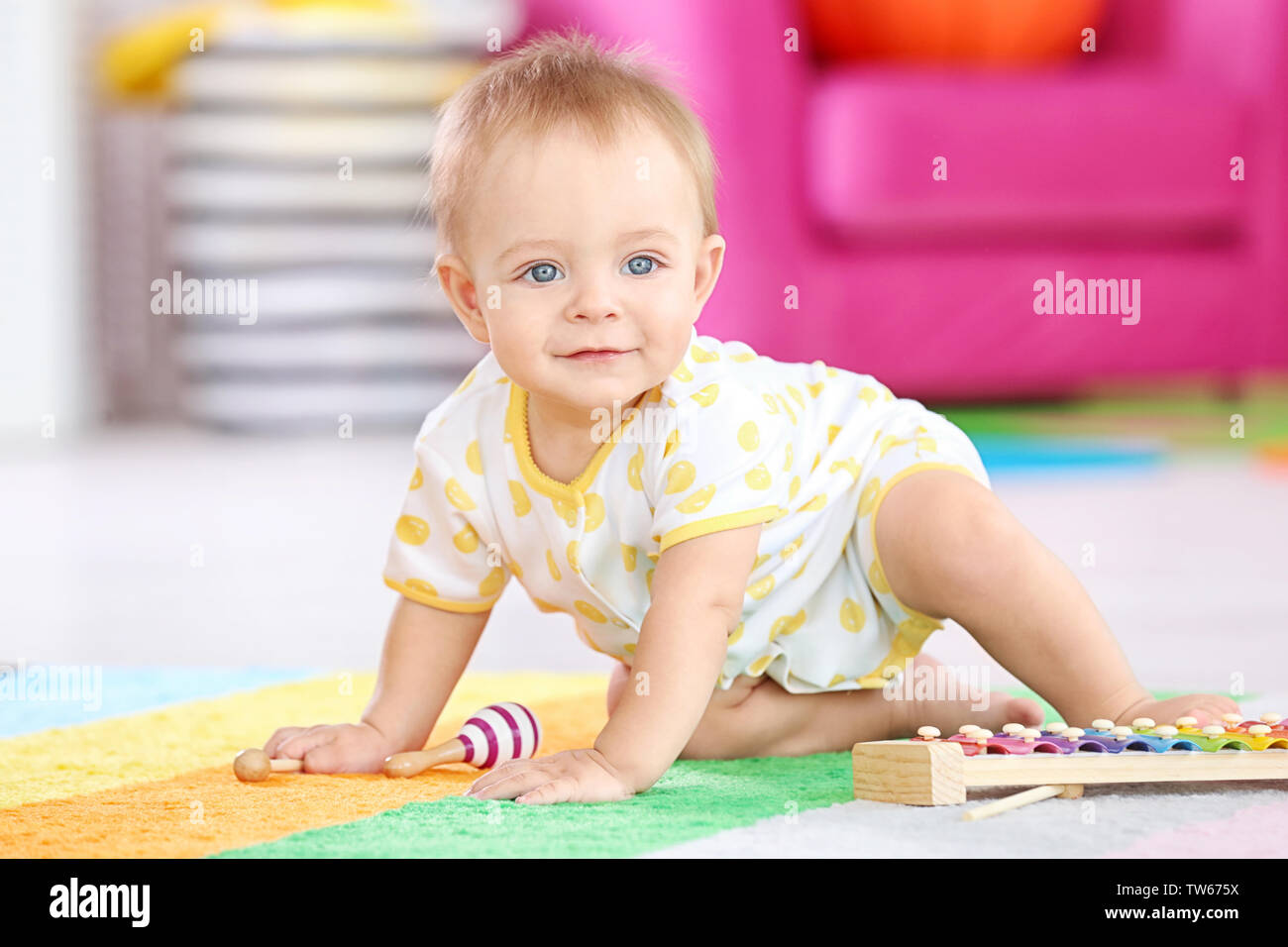 Cute little baby playing with musical instrument at home Stock Photo