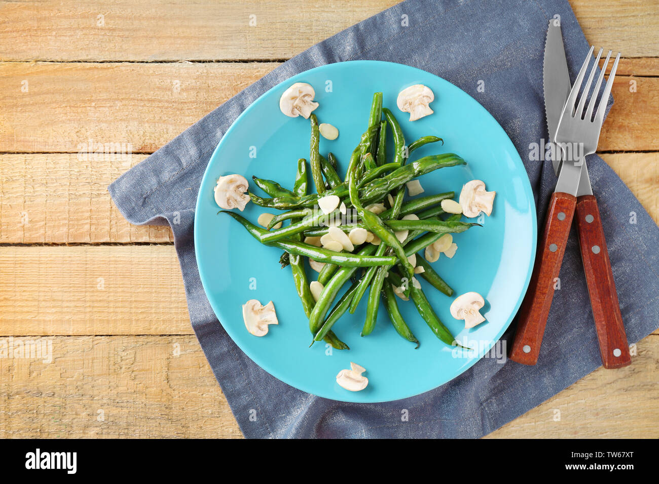 Plate with delicious green beans, almond and mushrooms on table Stock Photo