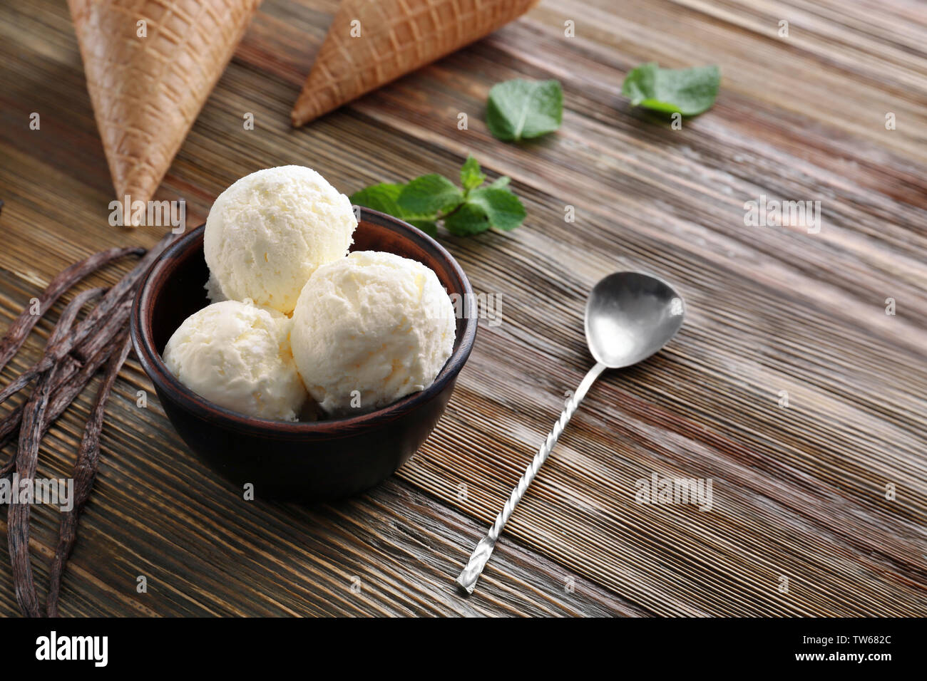 Bowl with yummy vanilla ice cream on wooden table Stock Photo - Alamy