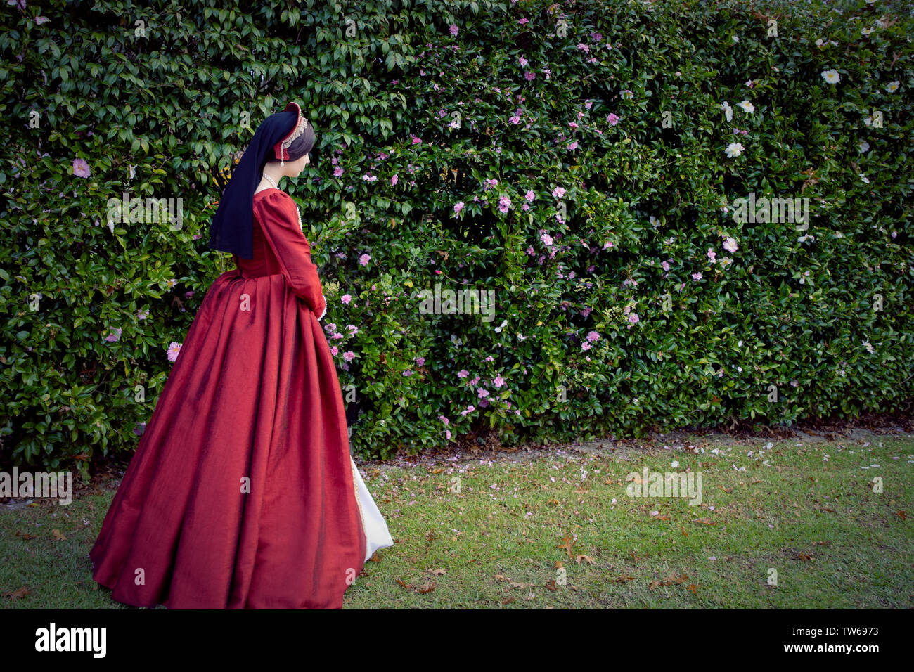 Tudor woman in red dress walking in garden Stock Photo Alamy