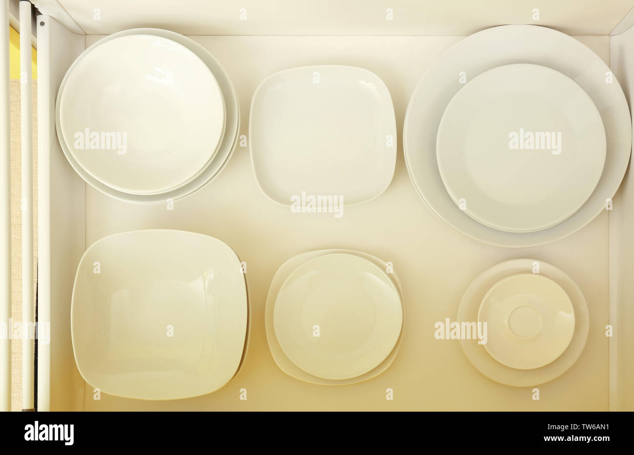 Set of ceramic plates in kitchen drawer Stock Photo Alamy