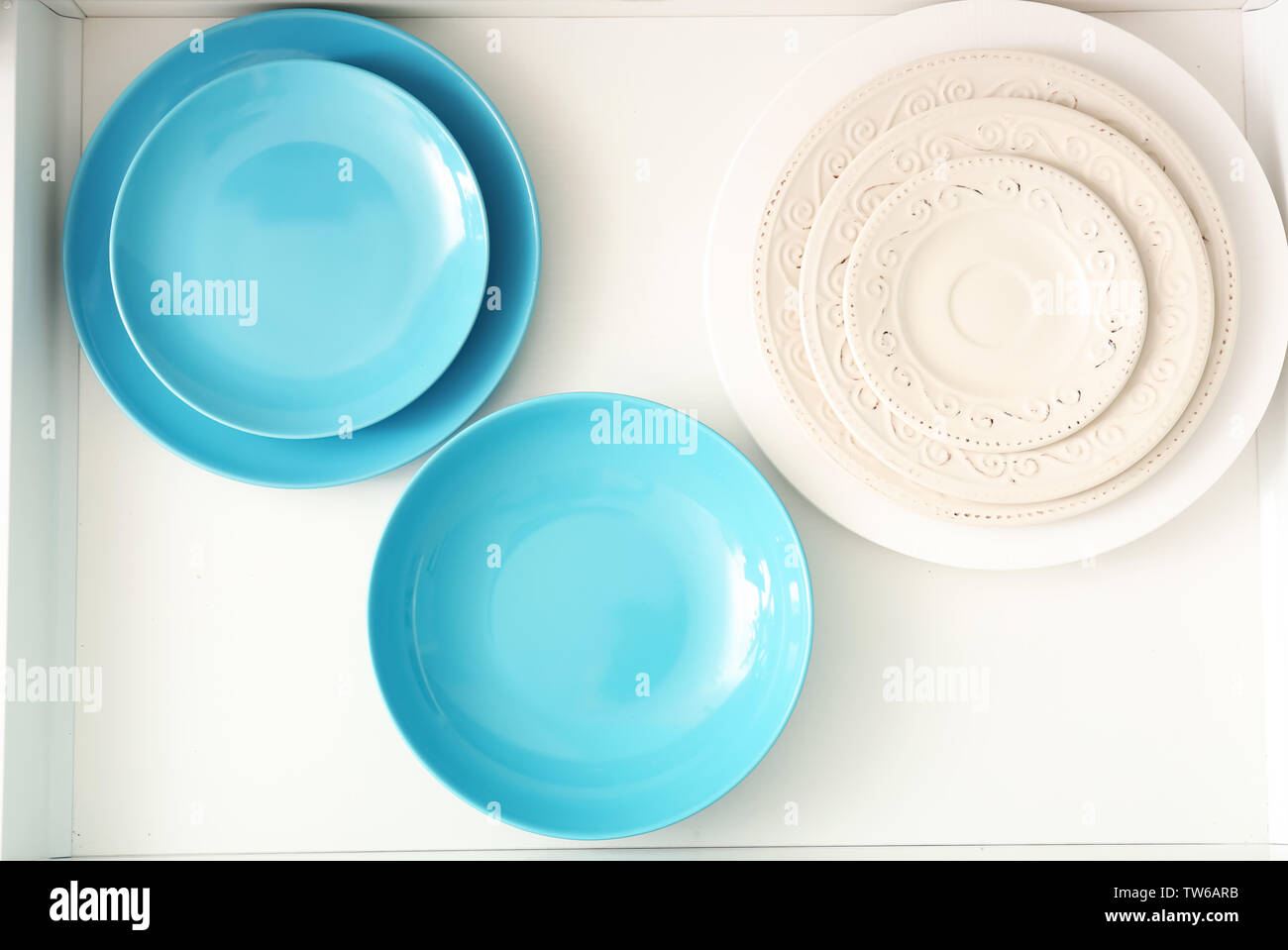 Set of ceramic plates in kitchen drawer Stock Photo Alamy